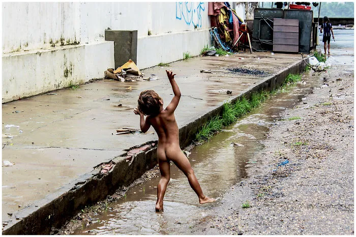 Happy Boy Dancing Because The Rain Stopped. Kratie, Cambodia. By: Laura Schillemans