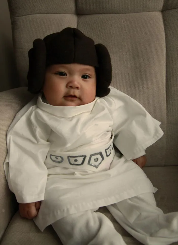Baby dressed in a creative Halloween costume sitting on a chair, showcasing children's Halloween costume ideas.