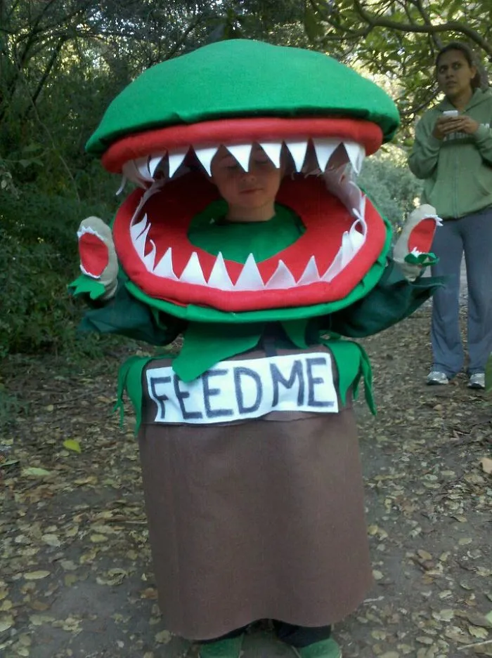 Child wearing a creative plant monster Halloween costume in the woods, perfect for children's Halloween costume ideas.