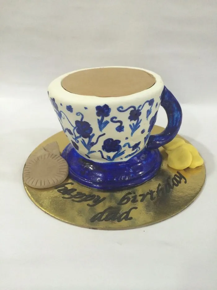 A Tea Cup Cake With Biscuits And Cookies