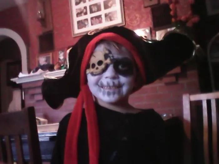Child dressed as a pirate with skull face paint and a black hat, showcasing children's Halloween costume ideas.