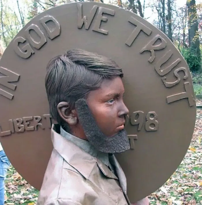 Child dressed as a penny coin with painted face and beard, showcasing unique children's Halloween costume ideas outdoors.