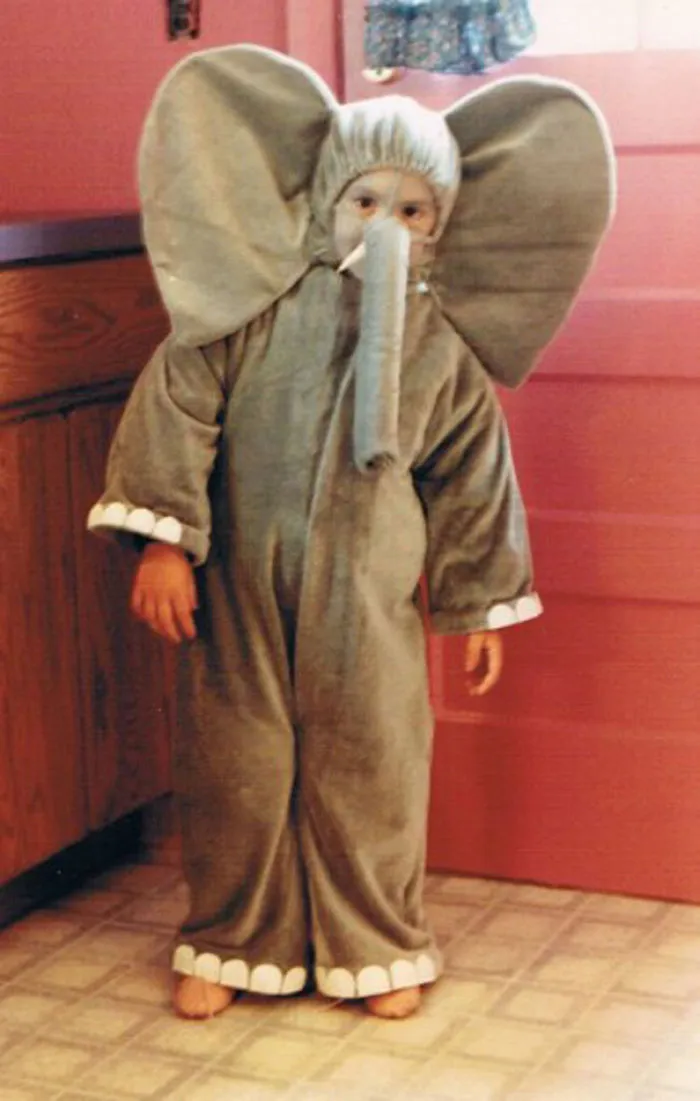 Child in elephant costume standing indoors, showcasing a creative children's Halloween costume idea.