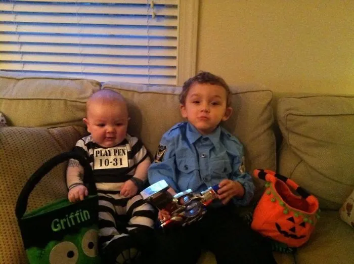 Two young children in Halloween costumes sitting on a couch with Halloween costume ideas for kids.
