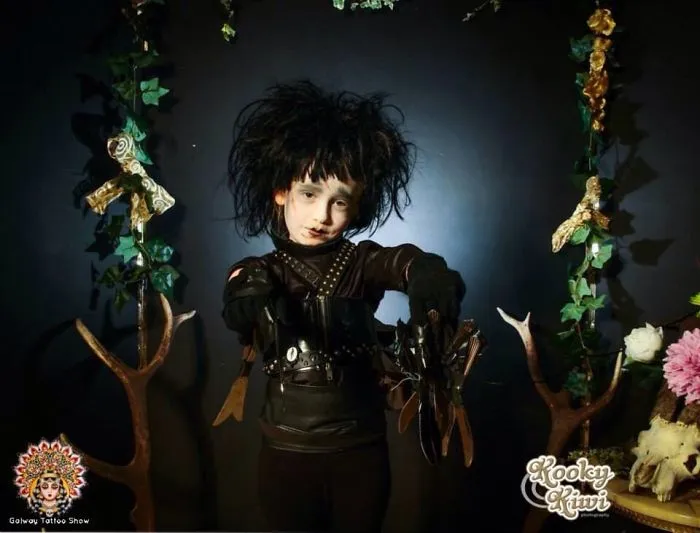 Child dressed in a creative Halloween costume with wild hair and black outfit for children's Halloween costume ideas.