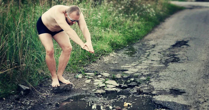 Friends Take Funny Pothole Photos To Draw Government's Attention To Poor Road Conditions In Kaunas