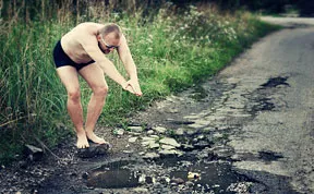 Friends Take Funny Pothole Photos To Draw Government's Attention To Poor Road Conditions In Kaunas