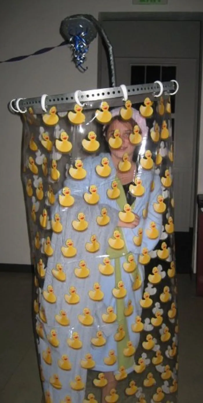 Child wearing a creative children's Halloween costume with a shower curtain decorated with rubber duck stickers.