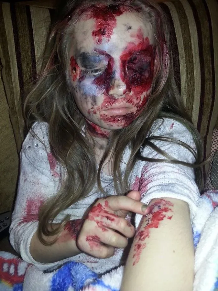 Child dressed in a scary Halloween costume with fake blood and face paint showing a zombie or horror look for kids.