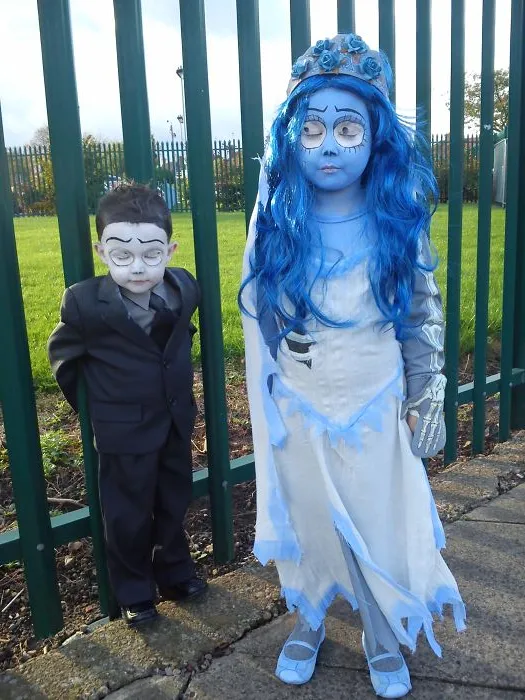 Two children in detailed Halloween costumes with face paint, showcasing creative children's Halloween costume ideas outdoors.