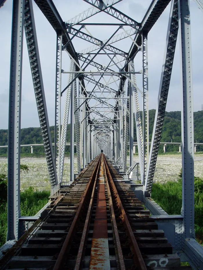 Steel railway bridge with intricate beams and tracks stretching into the distance, showcasing a mystical bridge scene.