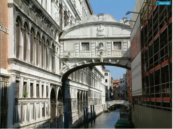 Mystical stone bridge over a canal between historic buildings in Venice, showcasing timeless architecture and serene waters.