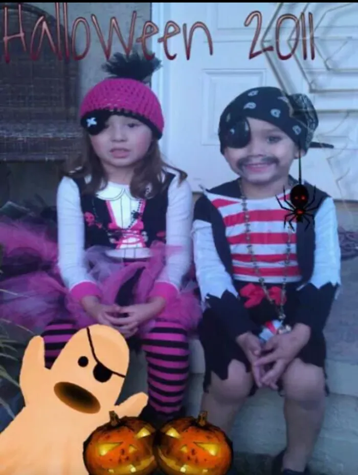 Two children dressed as pirates sitting outside with Halloween decorations for children’s Halloween costume ideas.