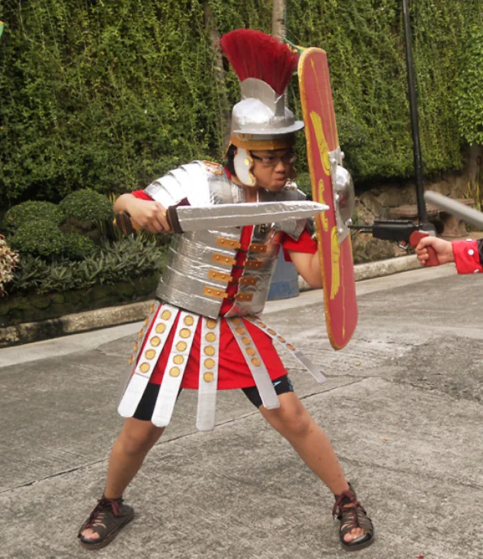Child dressed in a Roman soldier Halloween costume holding shield and sword, showcasing creative children's Halloween costume ideas.