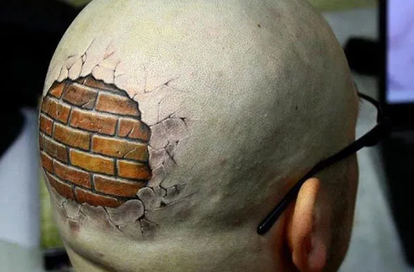 3D tattoo of a brick wall illusion on the back of a person's shaved head.