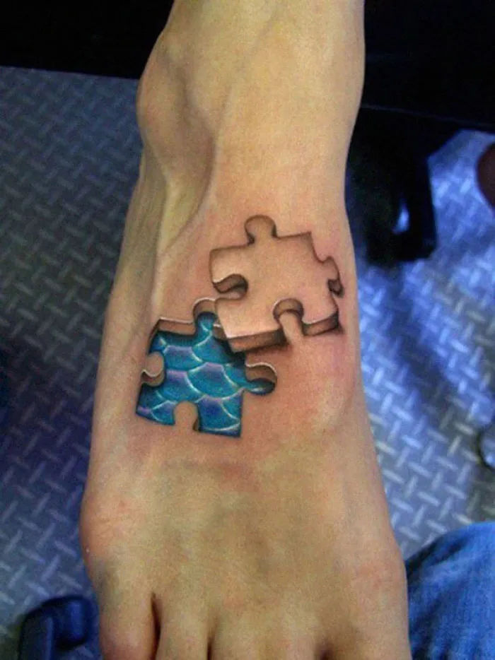 3D tattoo of puzzle pieces on foot, creating the illusion of missing skin and revealing blue scales underneath.