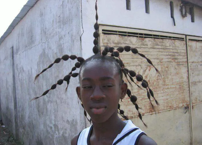 A person with one of the craziest haircuts featuring elaborately styled braids in a spider-like pattern.