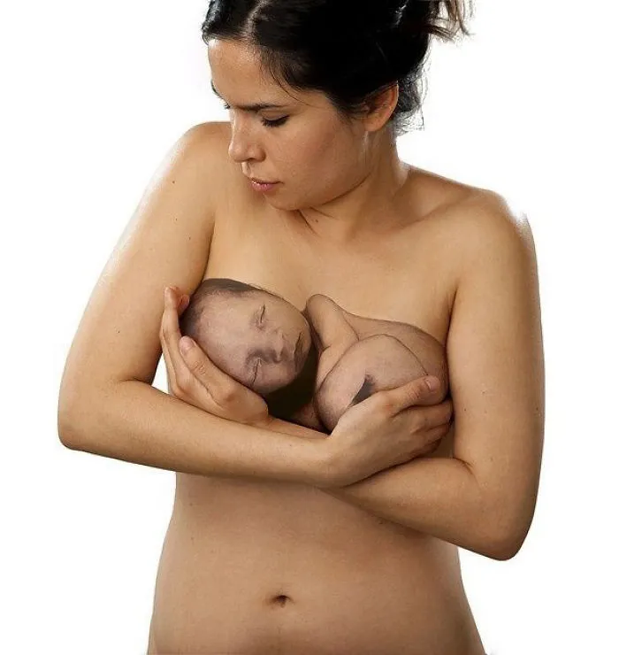 A woman with a realistic 3D tattoo of a baby on her arm, showcasing mind-bending artistry.