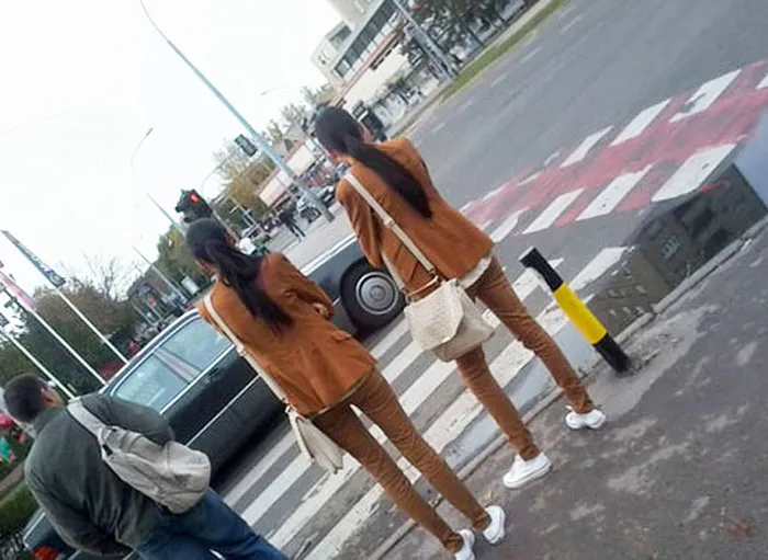 Two womans standing near each other and wearing same clothes