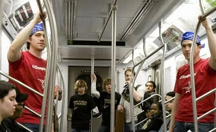 Two man and boys standing in the train and looking similar