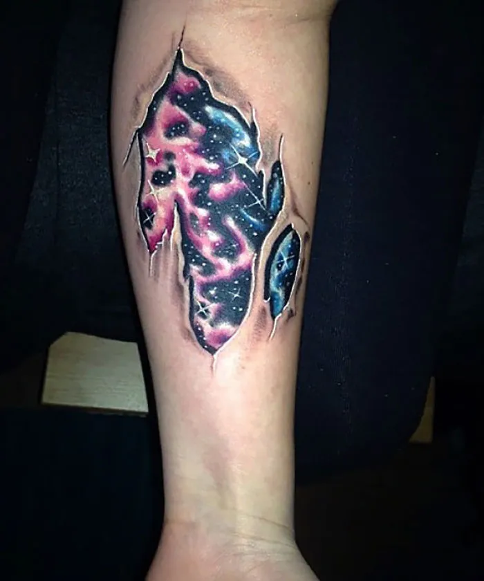 Colorful cosmic tear tattoo on an arm, featuring vibrant galactic imagery, perfect for astronomy lovers.