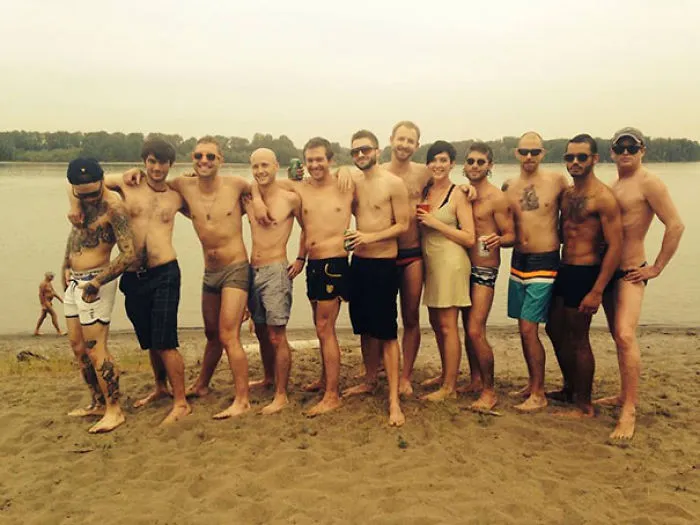 Group on the beach posing for a photo, with a hidden detail to discover.
