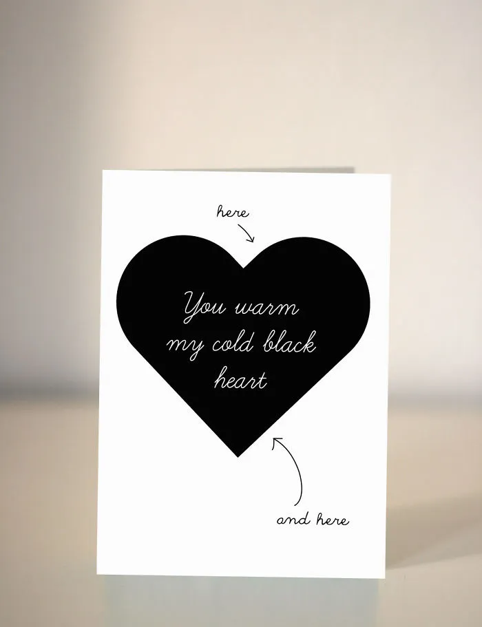 Unconventional Valentine's Day card with a black heart stating "You warm my cold black heart" in a minimalist style.