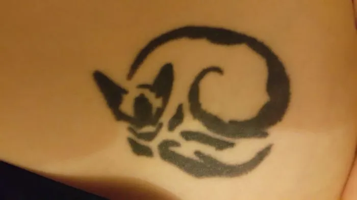 Simple line art cat tattoo design on skin.
