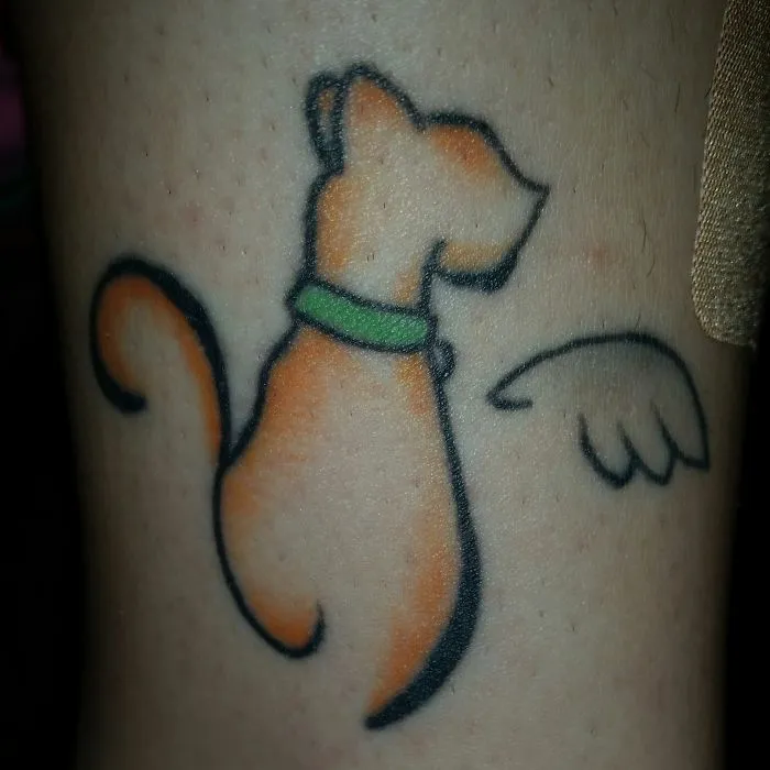 Simple cat tattoo design featuring a minimalist line art style with a green collar and wing detail.