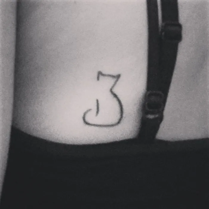 Minimalistic line art cat tattoo on skin.