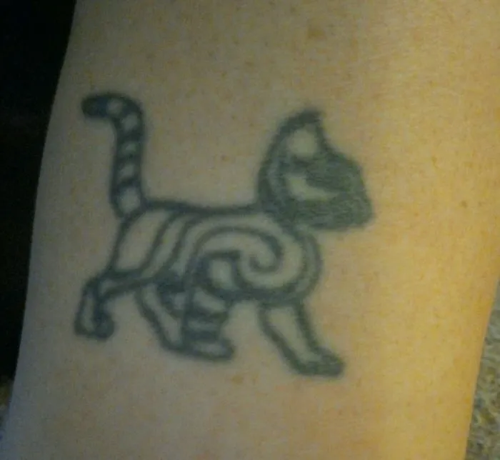 Simple cat tattoo in line art on skin, featuring abstract patterns for cat lovers.