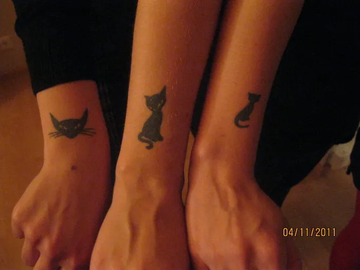 Simple cat tattoos on forearms, featuring minimalistic line art for cat lovers.