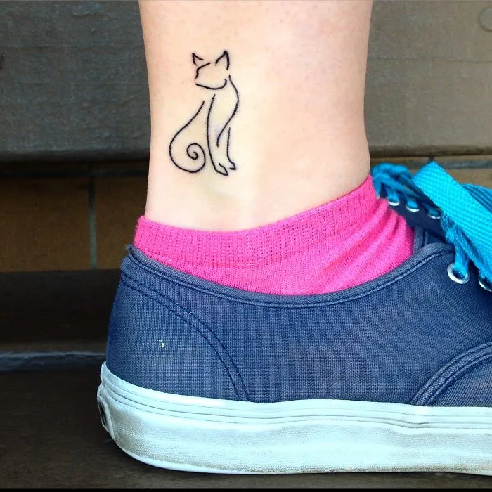 Simple cat line art tattoo on ankle, perfect for cat lovers.