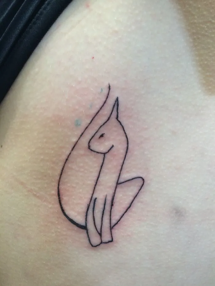 Simple line art cat tattoo design on skin, showcasing minimalistic style for cat enthusiasts.