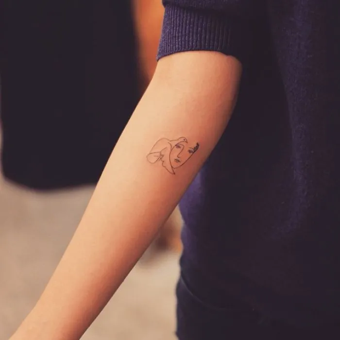 Picasso-inspired tattoo on forearm featuring abstract face, perfect for art lovers seeking unique ink ideas.