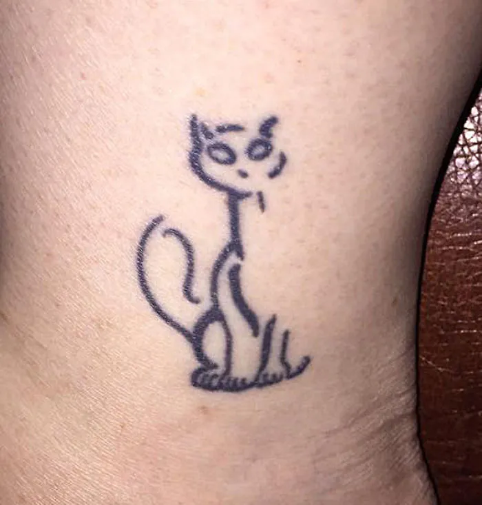 Simple cat tattoo design in line art on ankle for cat lovers.