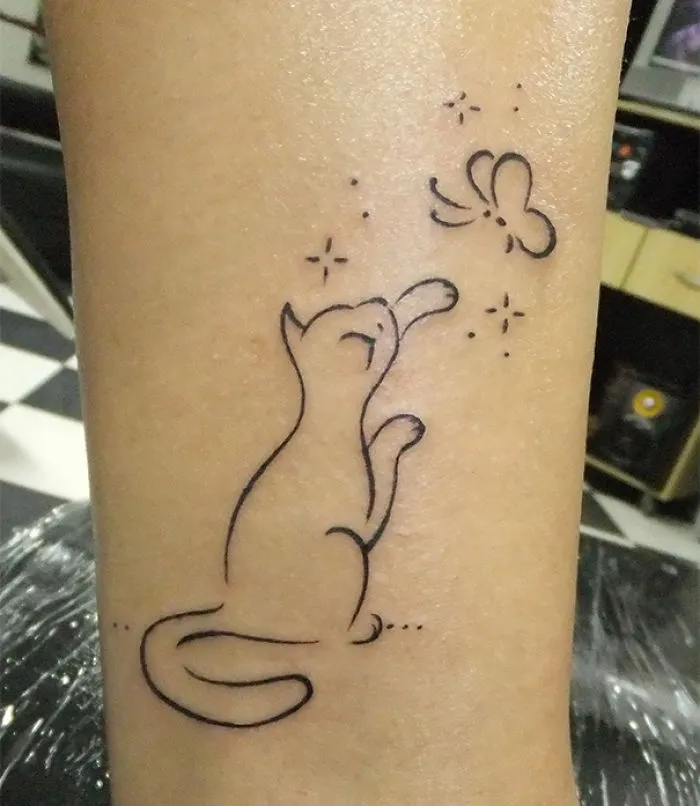Line art cat tattoo with a butterfly, perfect for cat lovers.