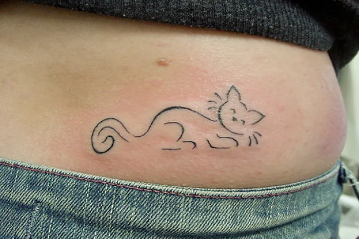Minimalist line art cat tattoo on skin, showcasing simple cat designs for enthusiasts.