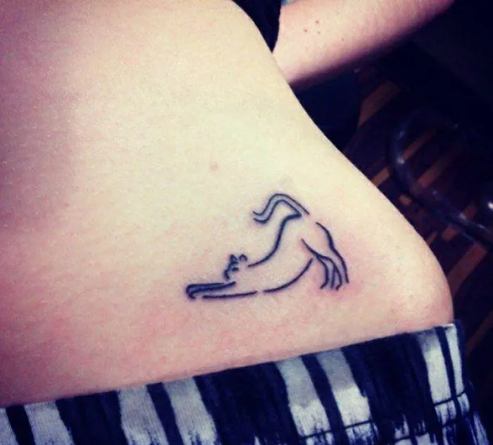 Line art cat tattoo design on skin, showcasing a simple and elegant style for cat lovers.