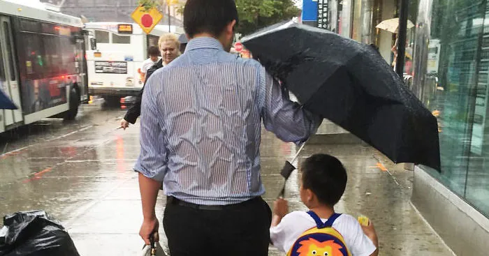 Soaked Dad Protecting His Schoolboy From Rain Shows What Parenting Is
