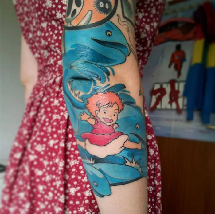 Colorful Studio Ghibli tattoo featuring a character swimming, inspired by Miyazaki films.