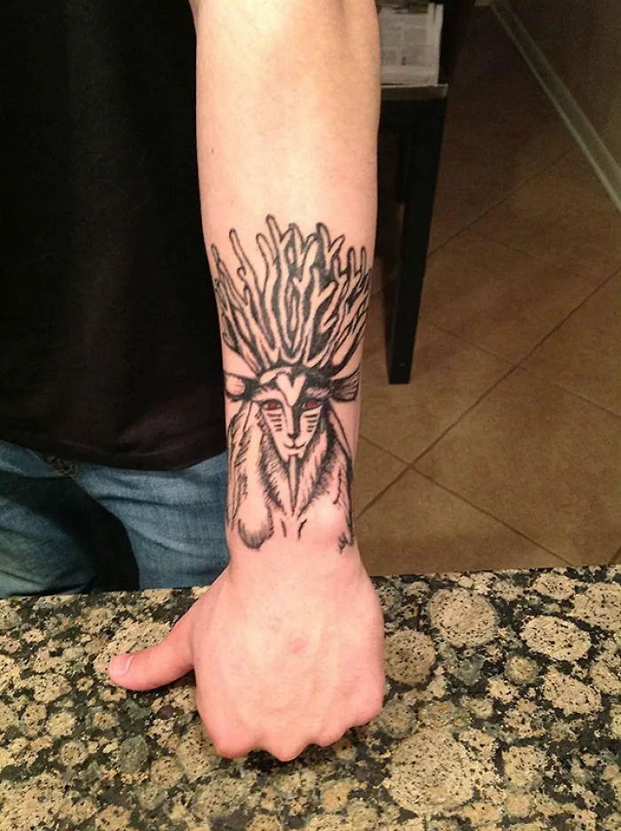 Studio Ghibli inspired tattoo featuring a mystical creature on a person's forearm.