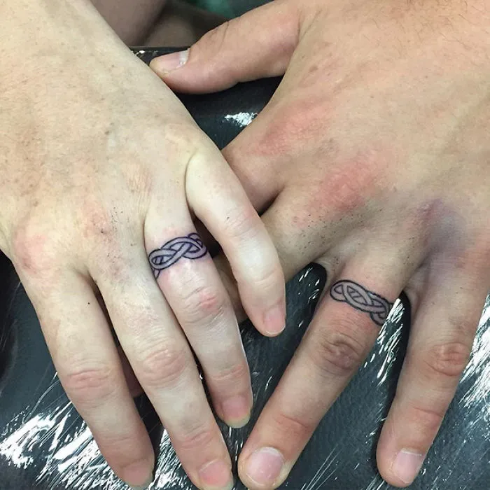 Matching wedding tattoos on couple's ring fingers, showcasing brave and unique commitment.
