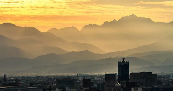 Living In The City Surrounded By Tall Mountains With Devine Spirits