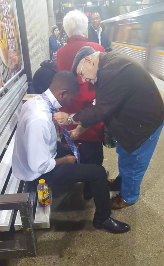 The Young Guy Sitting Down Was Struggling With His Tie When The Older Gentleman Moved Without Hesitation And Gave Him A Step-By-Step Tutorial