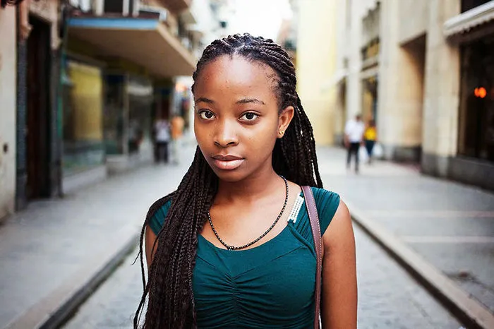 Young woman photographed by Romanian photographer, showcasing global beauty on a city street.
