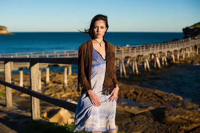 Woman in coastal setting, captured by Romanian photographer, highlighting global beauty.
