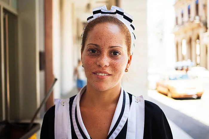 Portrait of a smiling woman in uniform, captured by a Romanian photographer, illustrating global beauty diversity.