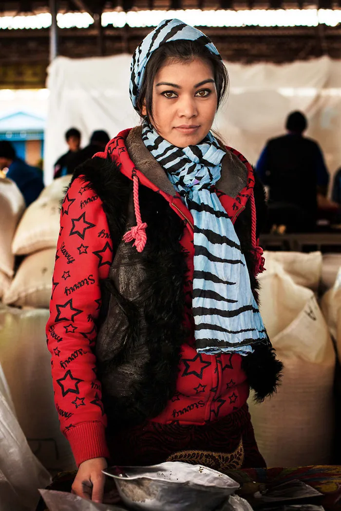 Romanian photographer captures a woman wearing a red star-patterned jacket and blue scarf, showcasing diverse beauty.