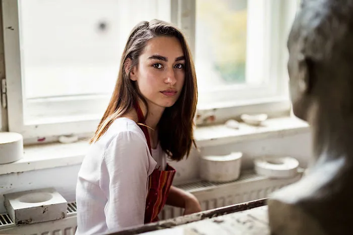 Romanian photographer captures woman sitting indoors, showcasing global beauty diversity.